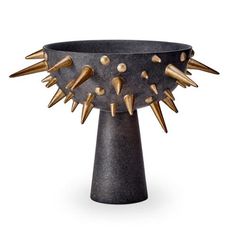 a black vase with gold spikes on it