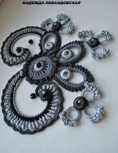 there are many crochet designs on the table together, but one is black and white