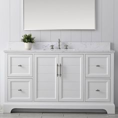 a white bathroom vanity with two sinks and a large mirror above the sink on the wall