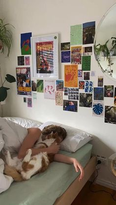 a woman laying in bed with her dog