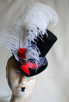 This elegant victorian riding ladies top hat is covered with fine black silk shantung. It is adorned with a lush white ostrich feather, white birdcage veil around the crown and red satin ribbon in a half bow along with dark silver decorative element. Also available in Total Black or Total White! Just click on the drop menu to pick which version you prefer! The Black/White/Red Version is READY TO SHIP out within a couple of days! Other color options are MADE TO ORDER! Fully lined with satin. Atta Curved Brim Top Hat For Kentucky Derby Costume, Victorian High Crown Costume Hat, Black Top Hat For Costume, Fitted Black Top Hat For Costume, Black Fitted Top Hat For Costume, Victorian Brimmed Costume Hats And Headpieces, Victorian Brimmed Costume Hat, Victorian Fitted Brimmed Costume Hats, Victorian Curved Brim Costume Hat