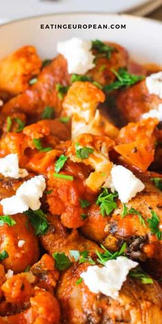 chicken with tomato sauce and feta cheese in a white bowl