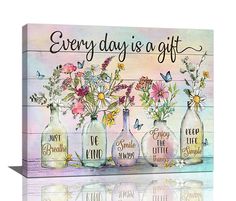 three glass vases with flowers and butterflies in them on a wooden sign that says, every day is a gift