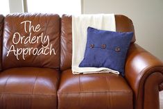 a brown leather couch with two pillows on it and the words the orderly approach written on them