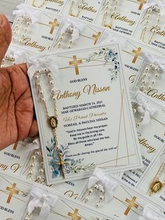 a person holding a rosary in front of a bunch of cards with cross on them