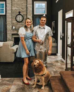 a man and woman standing next to a dog