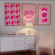 two pink posters on the wall above a white dresser