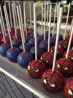 spiderman cake pops are lined up on a table