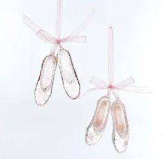 two pairs of ballet shoes hanging from strings