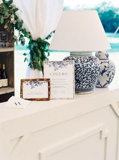 a table topped with vases and cards next to a lamp on top of a counter