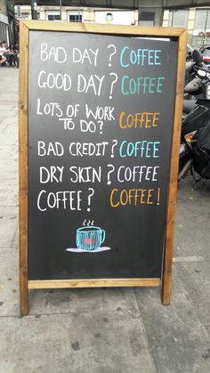 a blackboard sign on the sidewalk with coffee written in different languages and writing below it