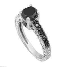 a black and white diamond engagement ring with an intricate design on the band, set in 18k white gold