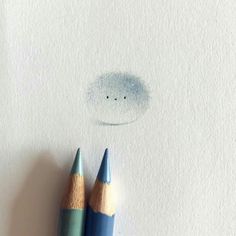 two colored pencils sitting next to each other on top of a piece of paper