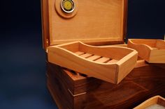 an open wooden box with two compartments and a lid on the inside that has something in it