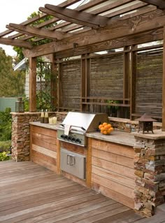 an outdoor kitchen on a deck with grill and sink