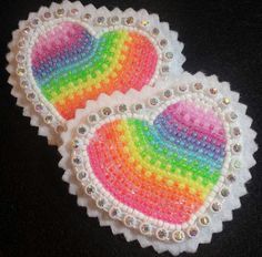 two rainbow heart shaped doily on a black surface