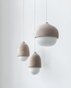 three light fixtures hanging from a white wall