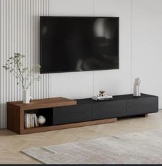 a living room with a large flat screen tv mounted on the wall and a plant in front of it