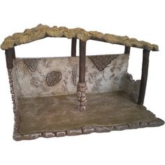 a bed made out of wood and stone with grass on the top, sitting in front of a white background