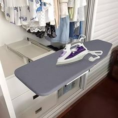 an ironing board sitting on top of a dresser