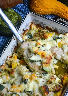 a casserole dish with chicken and vegetables in it on a blue table cloth