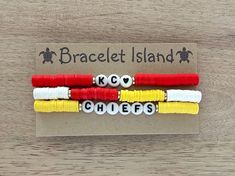 three bracelets with words spelled out in white, red, yellow and black beads