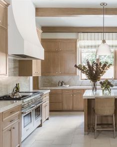 a large kitchen with wooden cabinets and marble counter tops, along with an island in the middle