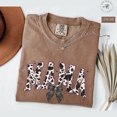 Embrace your love for western vibes with this trendy mama Shirt featuring a bold cow print design. Perfect for trendy moms, this tshirt combines comfort and flair, making it an ideal choice for casual days or cozy nights. The bold cow print adds a touch of rustic charm, blending modern fashion with Western vibes. A must-have for every mama who loves to make a statement!  Available in multiple sizes, also in sweatshirt, making the perfect addition to your wardrobe or a thoughtful gift for a speci Mama Shirt Ideas Vinyl, Relaxed Fit Cotton Cow Print Top, Fall Cow Print Cotton Tops, Mama Shirts Vinyl, Cow Print Design, Sweatshirt Western, Western Vibes, Trendy Mom, Sweatshirt Style