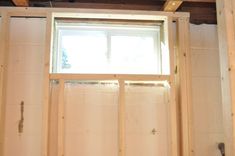 an unfinished room with wood framing and a window