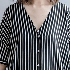 Feel comfortable while keeping it casual in our Black and White Striped Blouse. This blouse has an artsy style that is made to be your new go-to. Its flowy cotton material keeps it airy and light making it wearable even in the hottest months while its long sleeves and length makes it great for colder days. The monochromatic pattern and structured button-up style add a professional look that balances its easy-going fit. Wear this shirt day or night wherever you please, this versatile blouse will Striped Cotton V-neck Blouse, Effortless V-neck Blouse For Day Out, Flowy Cotton V-neck Blouse, Oversized V-neck Shirt For Summer, Relaxed V-neck Blouse For Day Out, Chic Oversized V-neck Shirt, Oversized V-neck Top For Summer, Relaxed Cotton Blouse For Daywear, Flowy Cotton Blouse For Spring