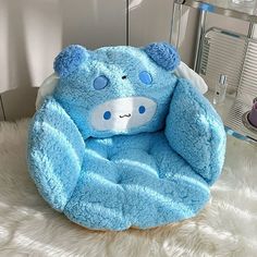 a blue teddy bear sitting on top of a fluffy white blanket in a room with a mirror