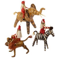 three wooden figurines of people riding on top of zebras and an elephant