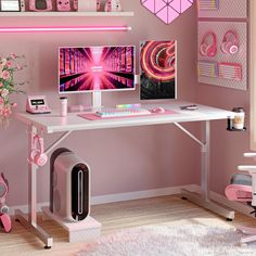 a desk with two computer monitors and headphones on it, in front of a pink wall