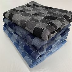 four towels stacked on top of each other in blue and grey colors with black dots