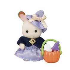 a small stuffed animal in a purple dress next to a basket with an orange pumpkin