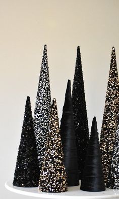 black and gold glittered cones are sitting on a white plate