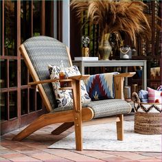 a wooden chair sitting on top of a rug next to a table and potted plant