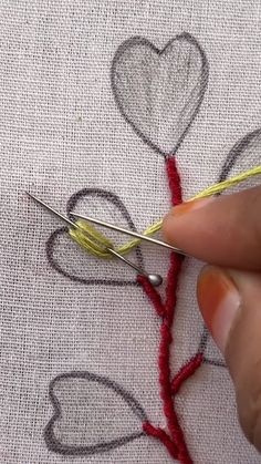 someone is stitching hearts on a piece of fabric