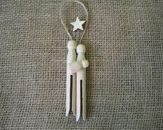 a white plastic figure hanging from the side of a string with a star on it