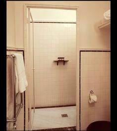 a bathroom with a shower, toilet and towel rack on the wall next to it