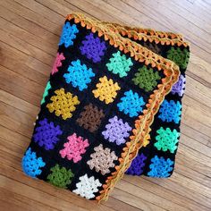 two crocheted squares are sitting on the floor