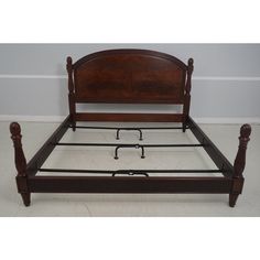 a wooden bed frame with metal legs and headboard