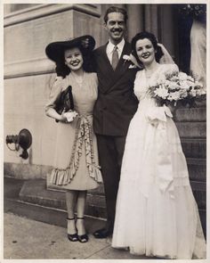 an old black and white photo of two women and a man standing next to each other