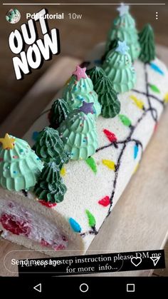 a cake with green frosting and christmas trees on it sitting on a cutting board