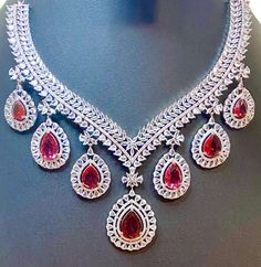 Experience the timeless elegance of our CZ American Diamond Necklace, featuring vibrant ruby pink colorstones. Perfectly complementing sarees, gowns or lehengas, this necklace adds a touch of glamour to any outfit. Complete the look with the included big earrings. Makes for a thoughtful and stylish gift. This jewellery set includes a necklace and matching earrings. Jewellery Care- Keep the jewellery dry, avoid contact with perfumes and water. Luxury Red Bridal Necklace For Celebration, Heavy Dazzling Necklace For Formal Occasions, Elegant Ruby Bridal Necklace With Stone Work, Dazzling Ruby Bridal Necklace For Parties, Luxury Red Jewelry Sets For Wedding, Luxury Ruby Bridal Necklace, Exquisite Red Bridal Necklace For Celebrations, Dazzling Red Bridal Necklace With American Diamond, Luxury Red Bridal Necklace For Wedding