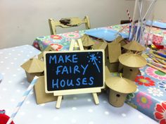 a sign that says make fairy houses sits on top of a table with other decorations