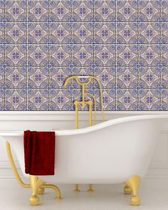 a bath tub sitting next to a wall covered in tile