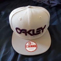 a white hat with the word okay written in purple on it's front side