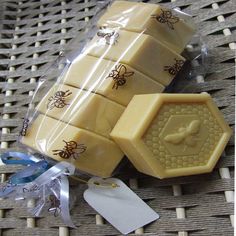 three bees soaps wrapped in cellophane on a wicker table with tags