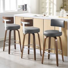 three bar stools in front of a kitchen counter